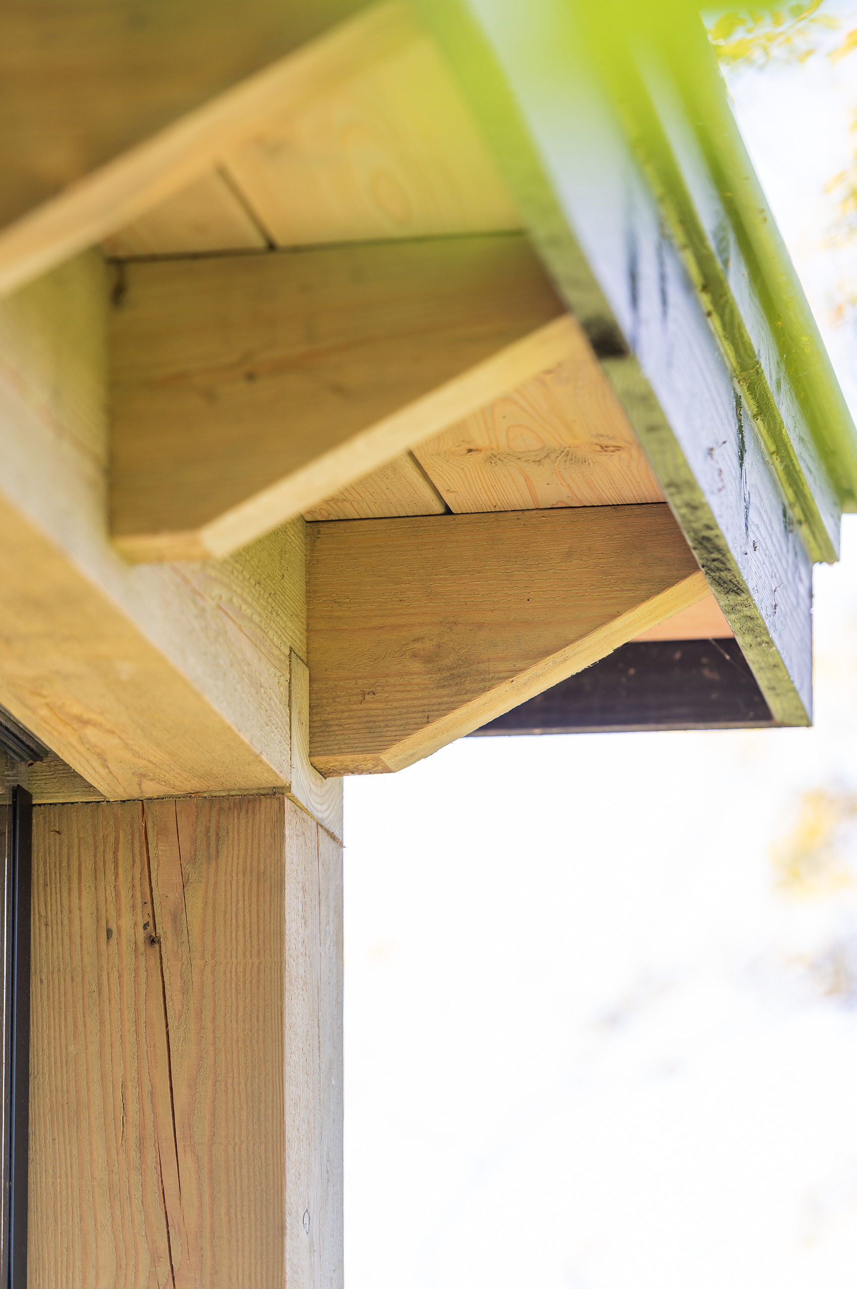 Houten overkapping aan de woning met veel glas