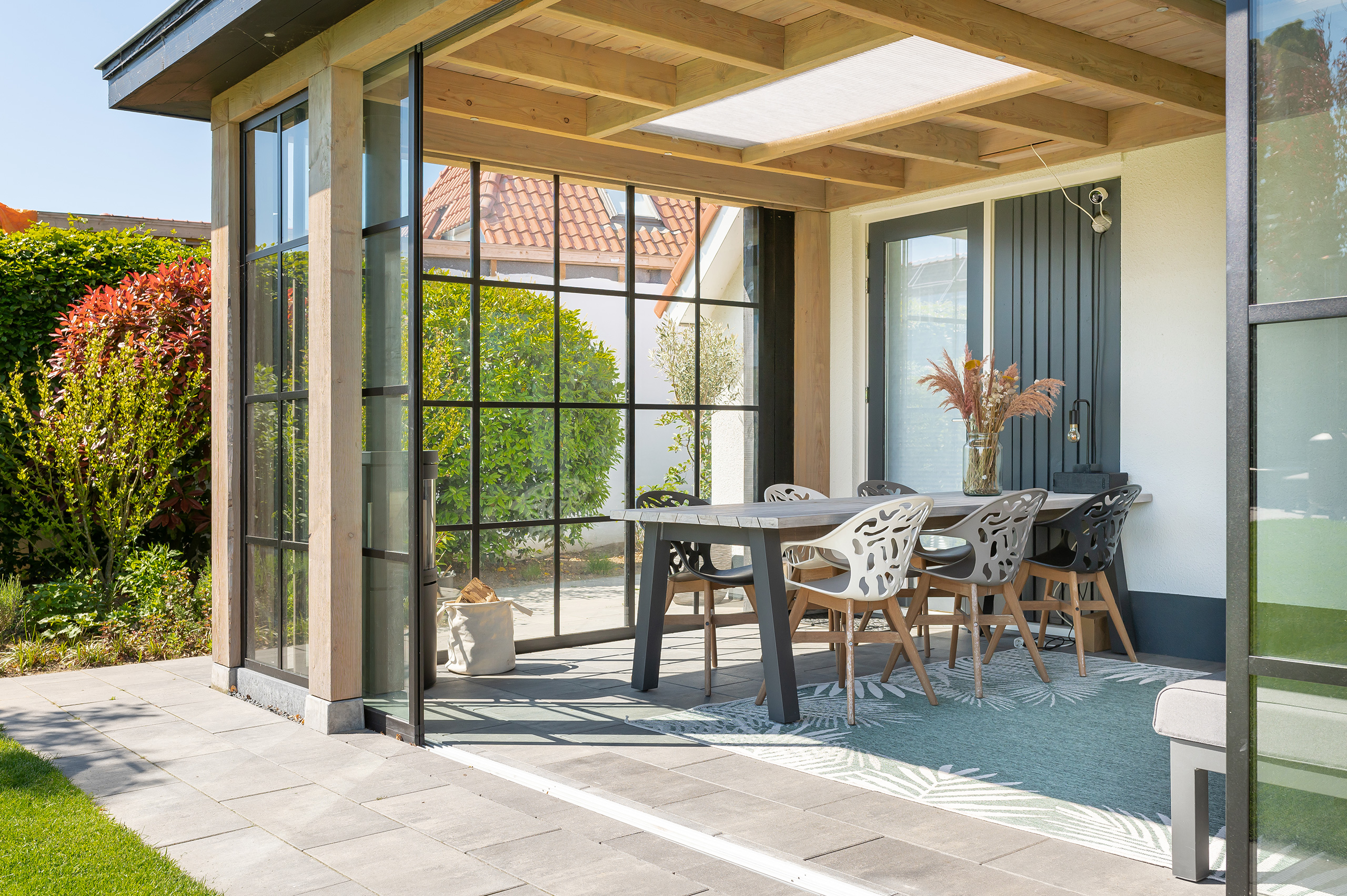 Buitenverblijf Lathum: overkapping aan huis met glazen schuifdeuren