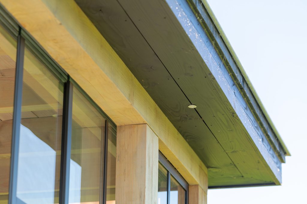 Buitenverblijf Lathum: overkapping aan huis met glazen schuifdeuren