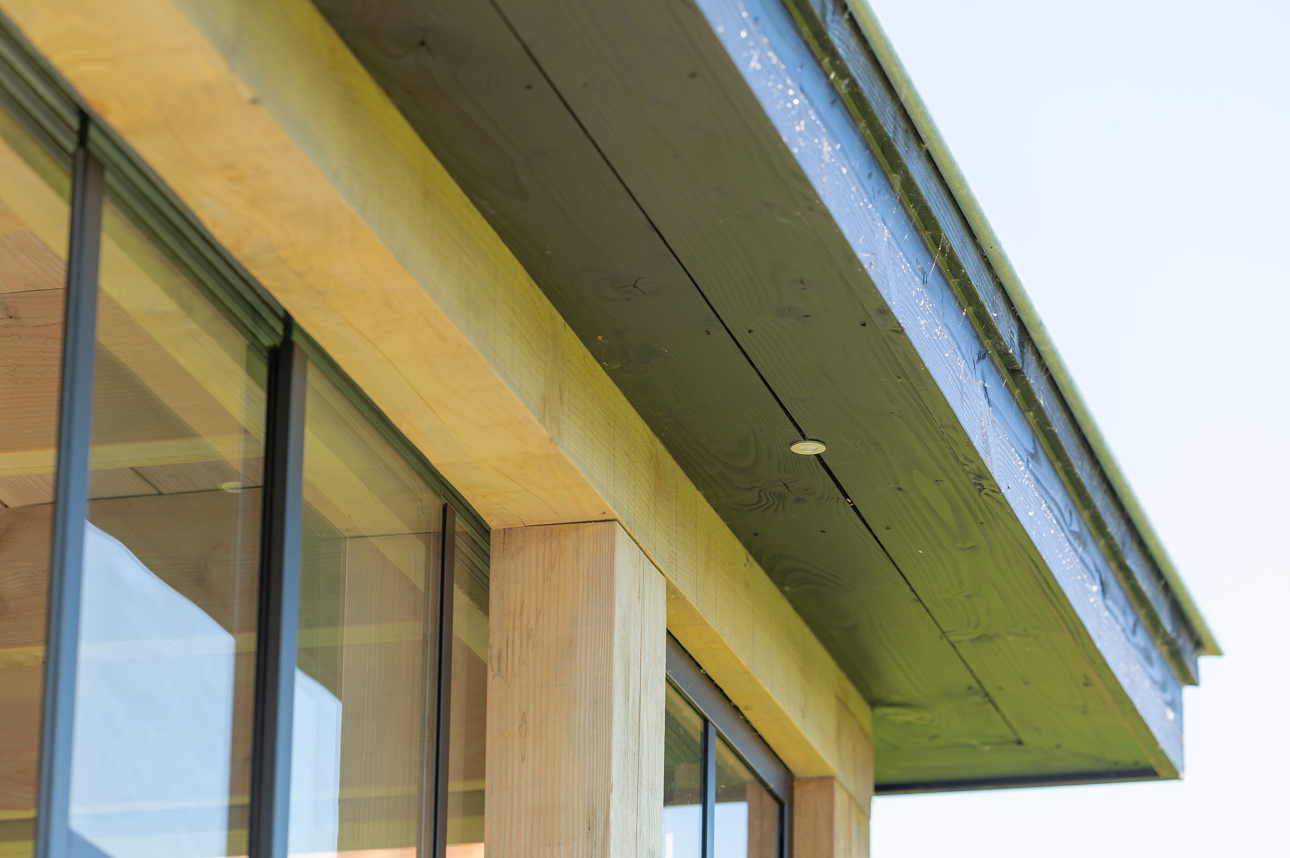 Buitenverblijf Lathum: overkapping aan huis met glazen schuifdeuren