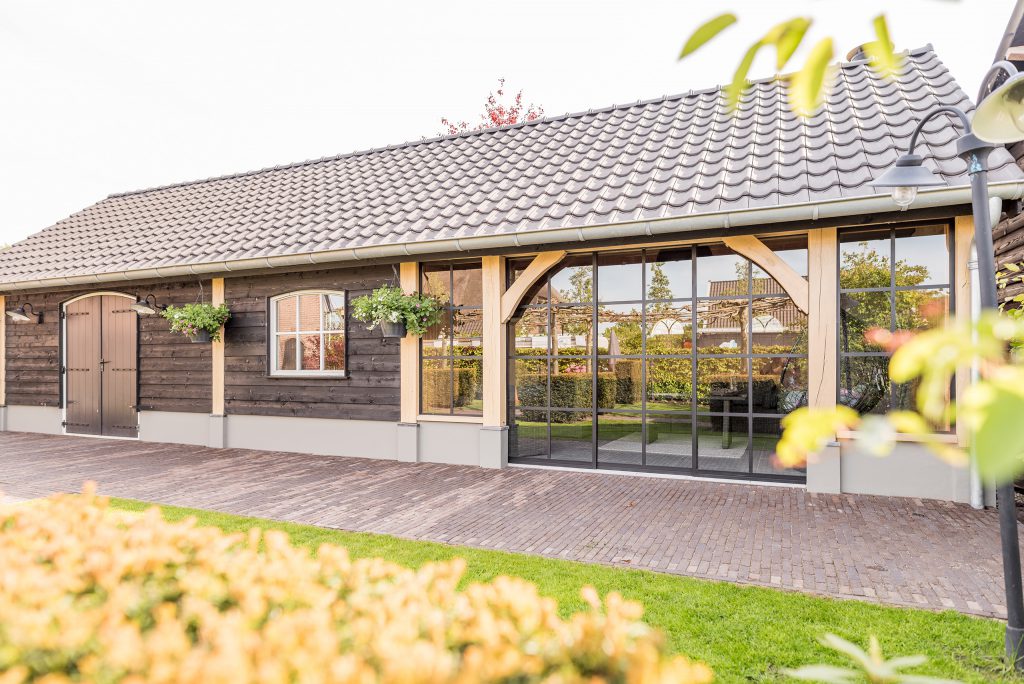 Deze houten tuinkamer in Kootwijkerbroek is gecombineerd met een overkapping en berging.