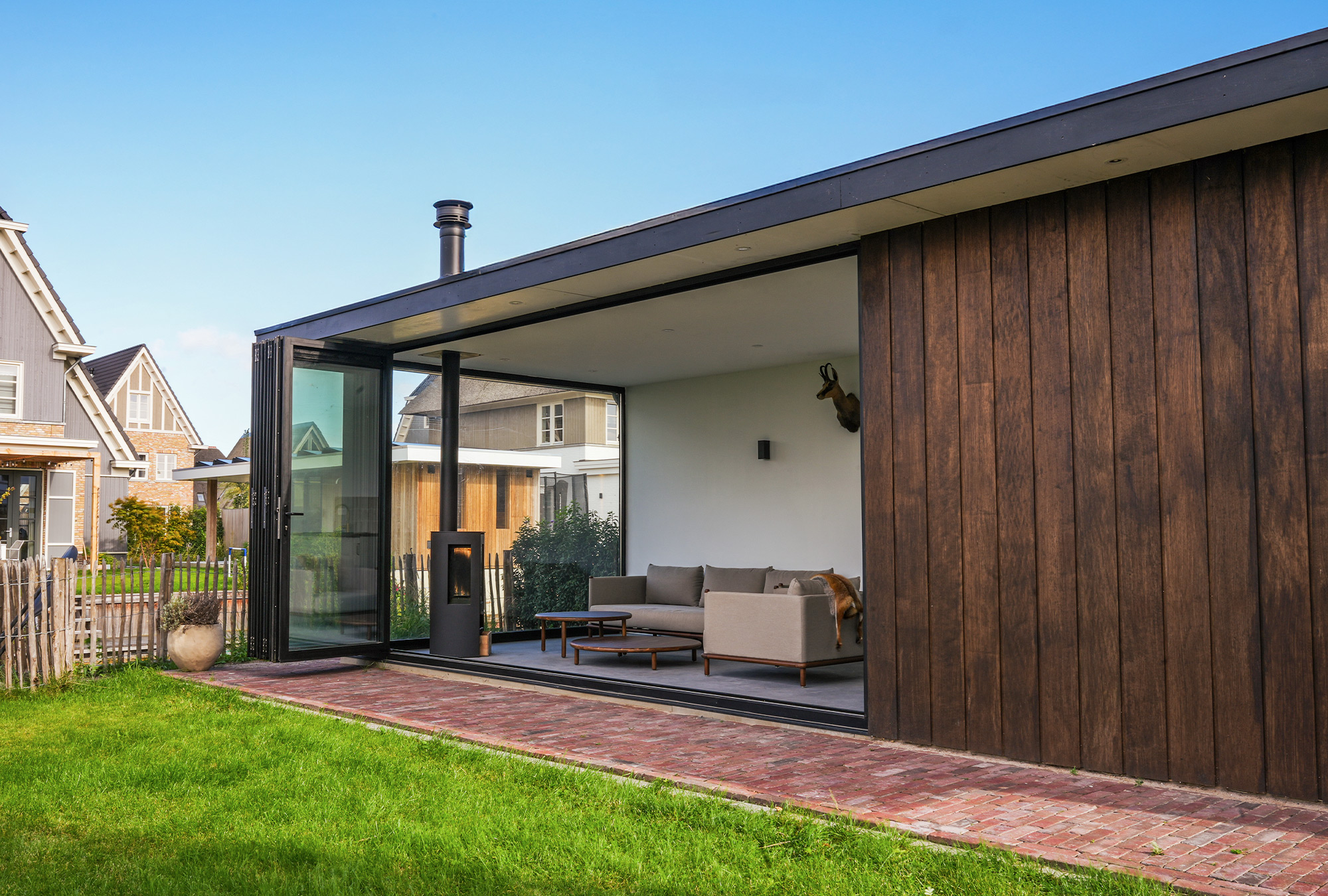 Glazen vouwwand in de tuinkamer? Bekijk het houten buitenverblijf in Weesp.